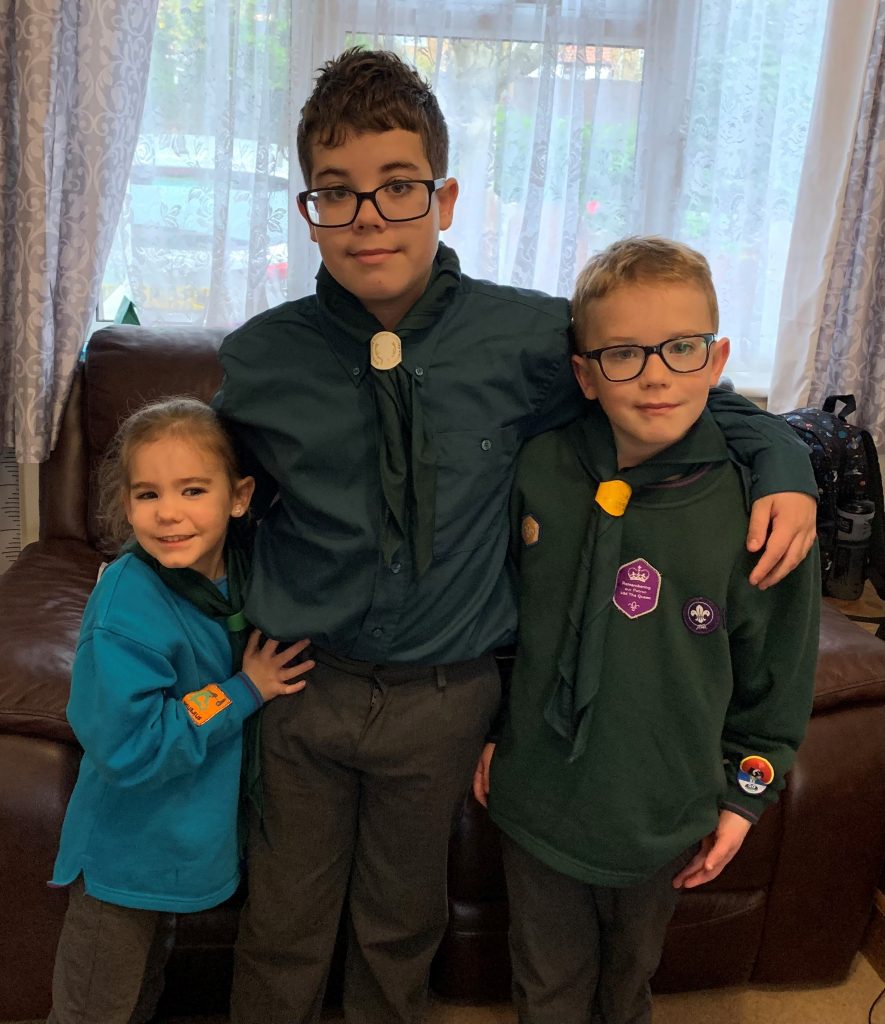 Sam, Ollie and their sister Charlotte linking arms.