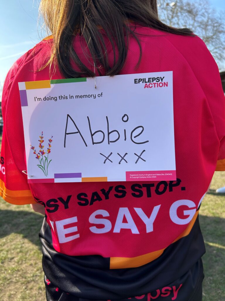 Back of a person in Epilepsy Action running top with an in memory message for Abbie