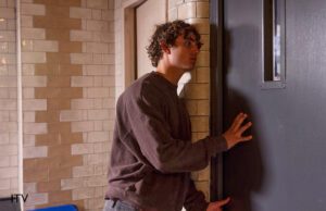 Brody from Coronation Street, standing in a cell in STC with his hand on the door asking for his epilepsy medication